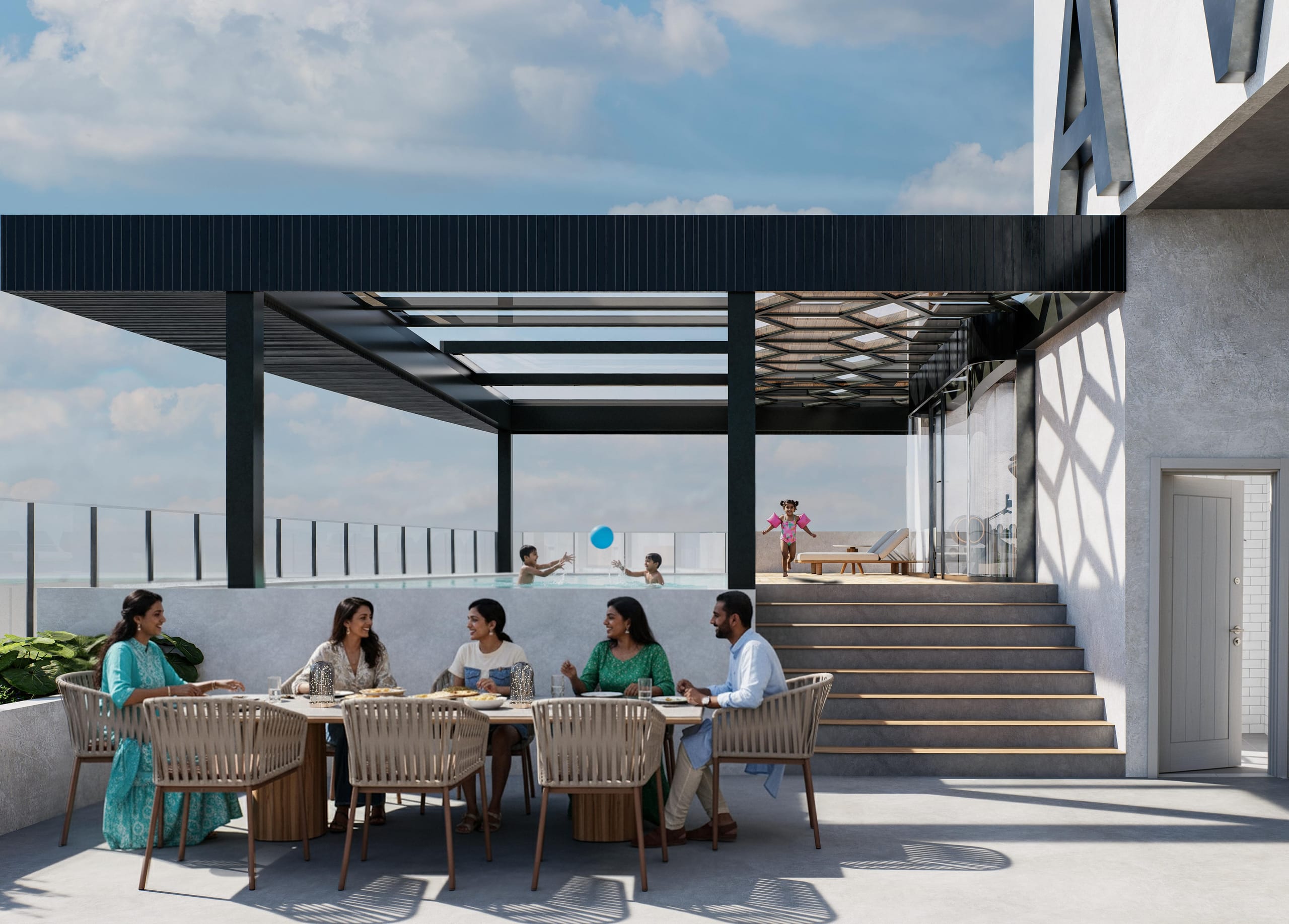 A family eating at a long table on the terrace while children play with a ball in the pool and a girl runs along the deck above the steps.