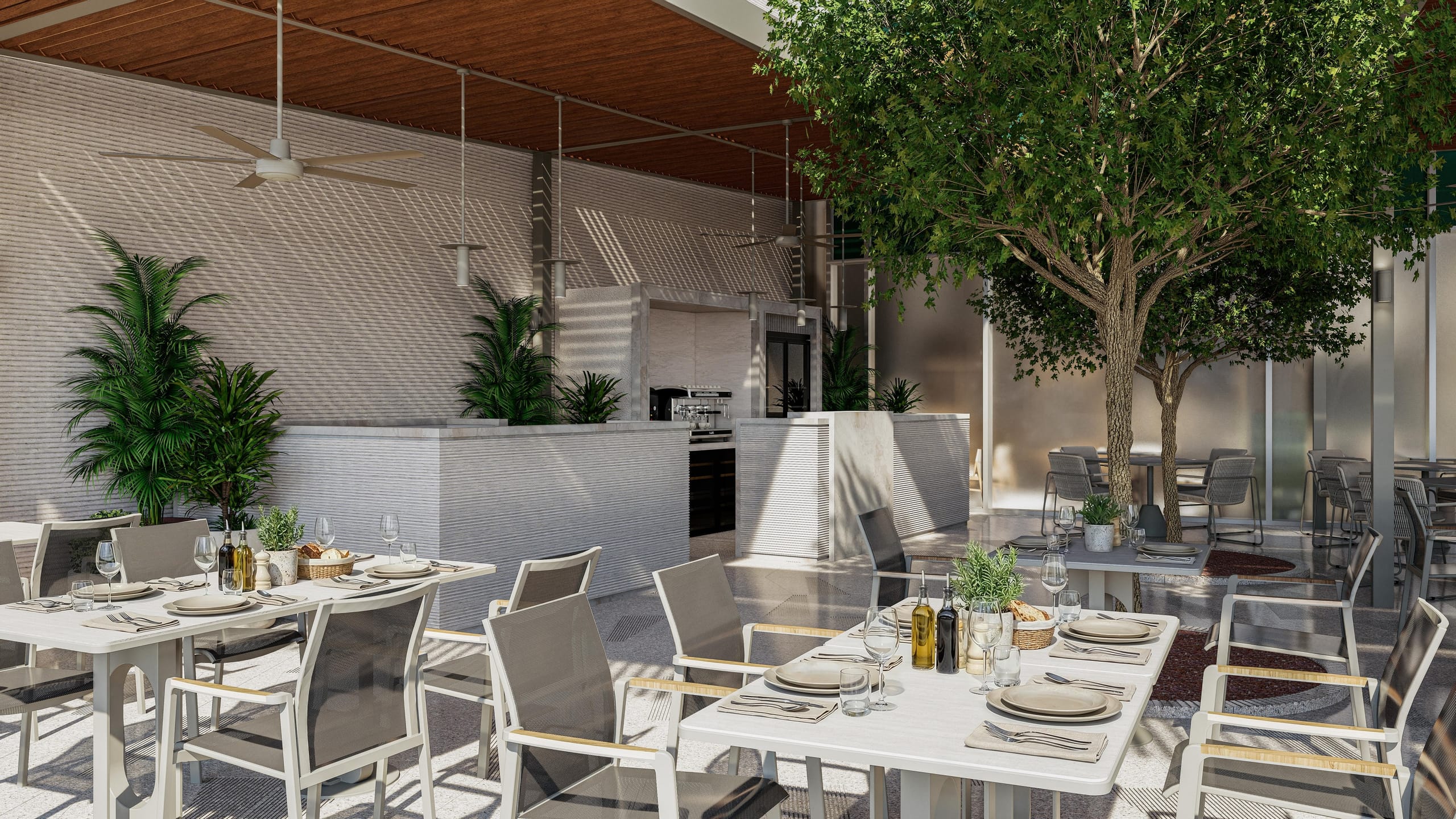 Terrace tables in front of the coffee bar, with trees planted in the floor and frosted glass screens behind.