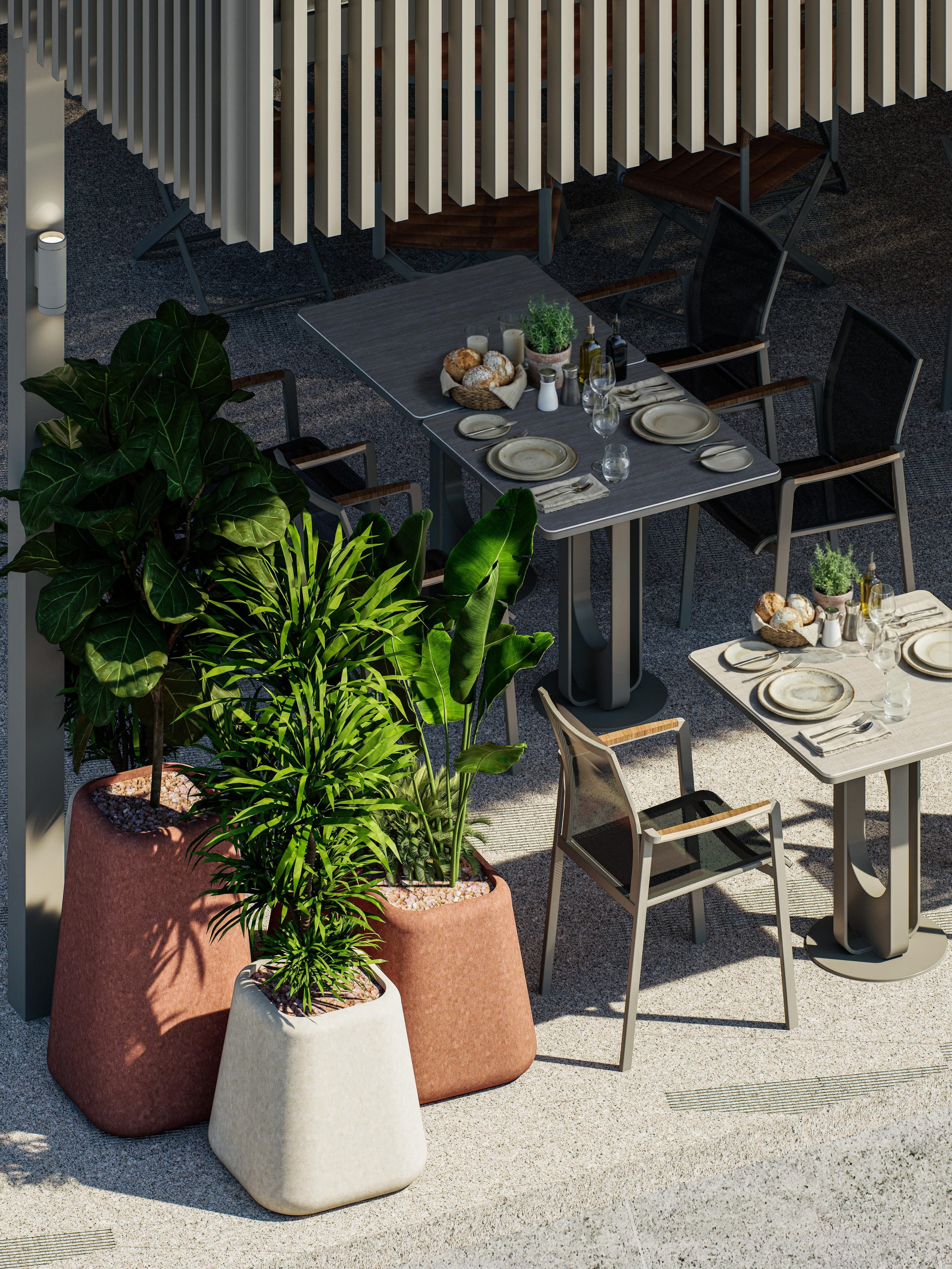 High view of laid tables and terracotta and white planters on the terrace.