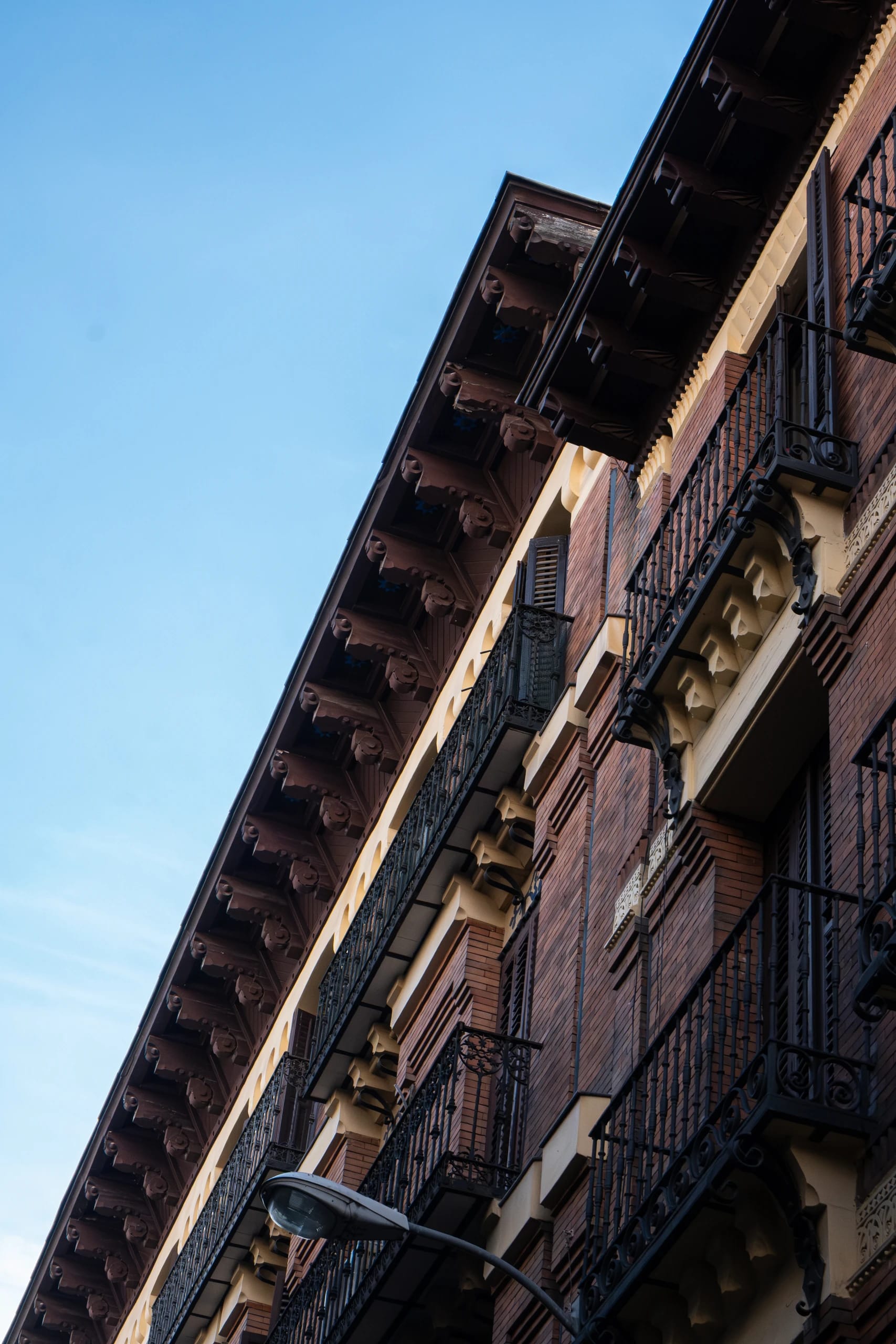 Brick facade and wrought-iron balconies seen from below