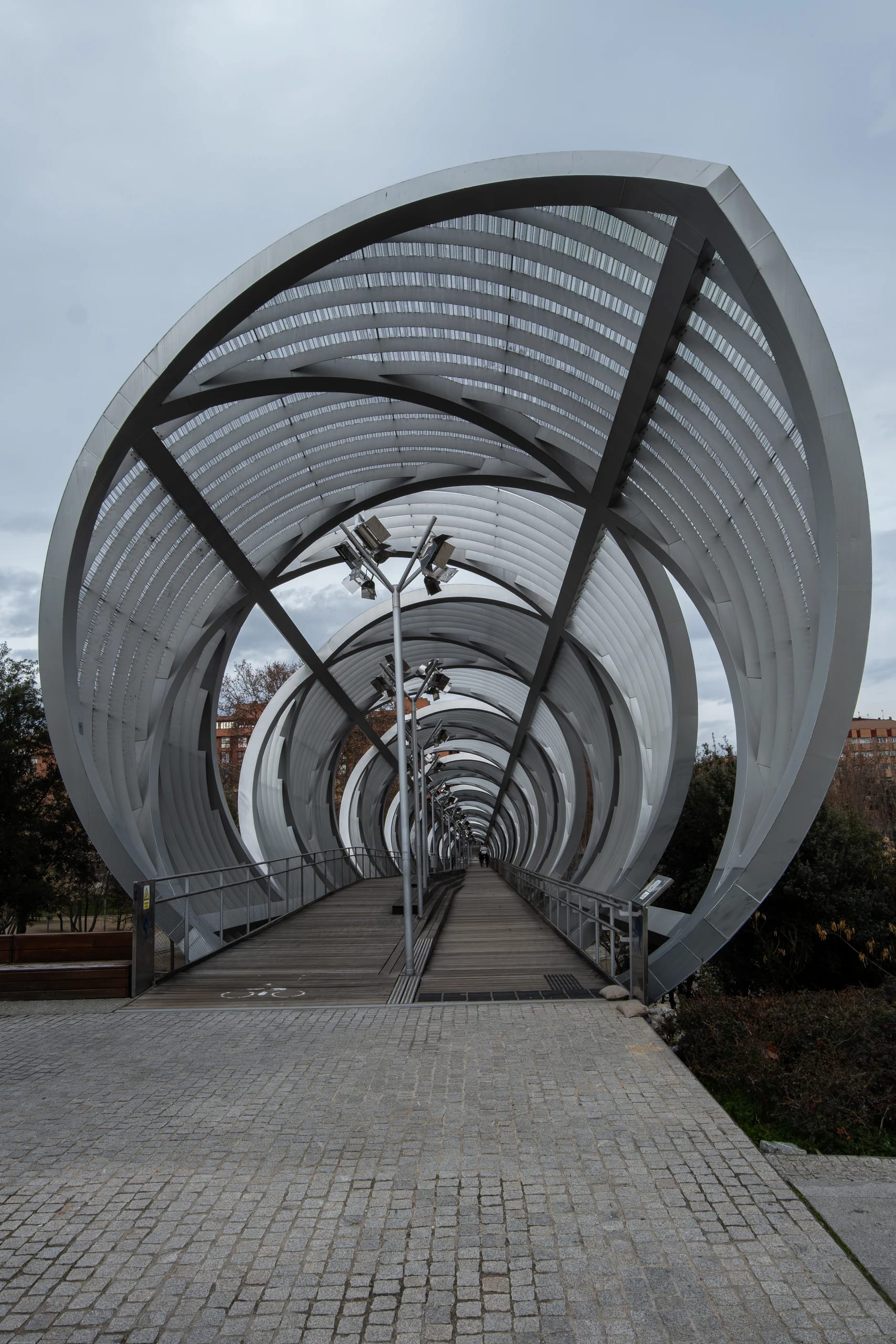 Spiralling white structural ribs over a pedestrian bridge