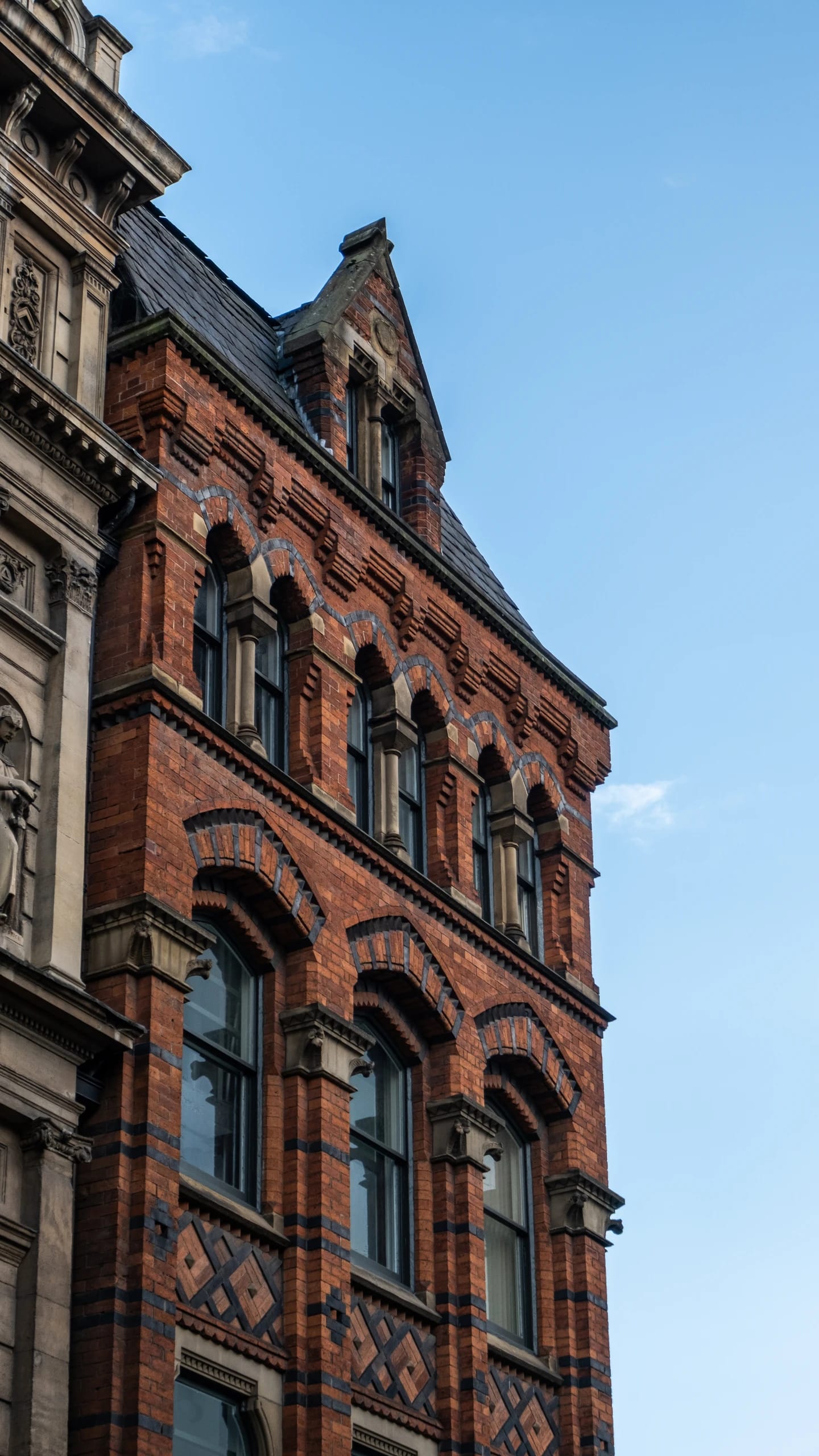 Arched windows and decorative brickwork against a blue sky