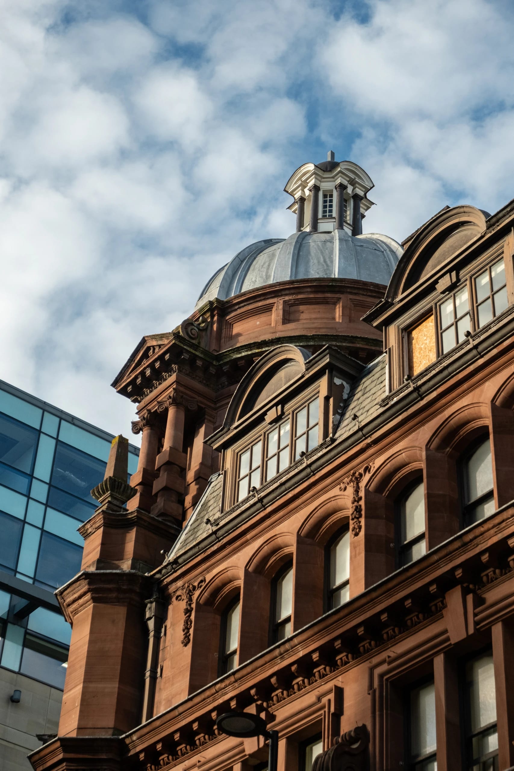 Sunlight on an ornate red-stone facade and domed roof