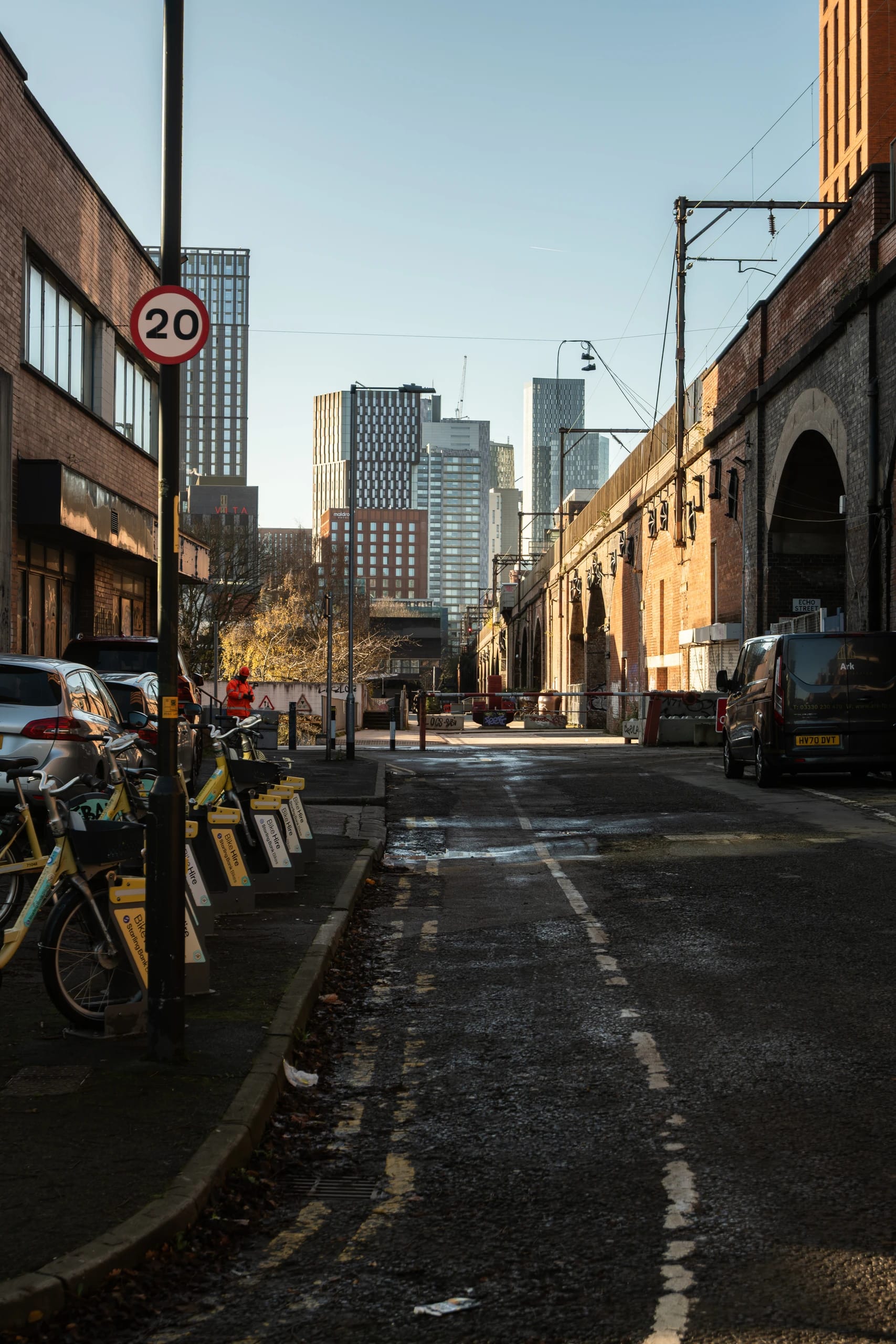 A Manchester street between railway arches and contemporary towers