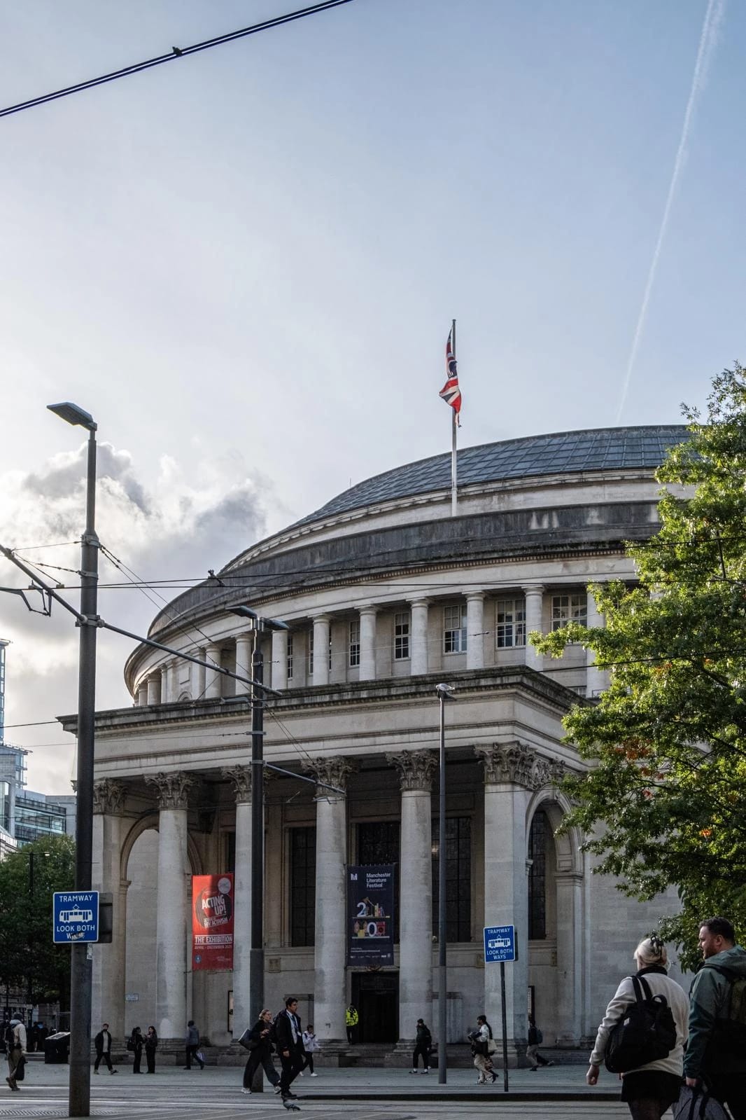 Manchester Central Library and pedestrians beneath tram wires