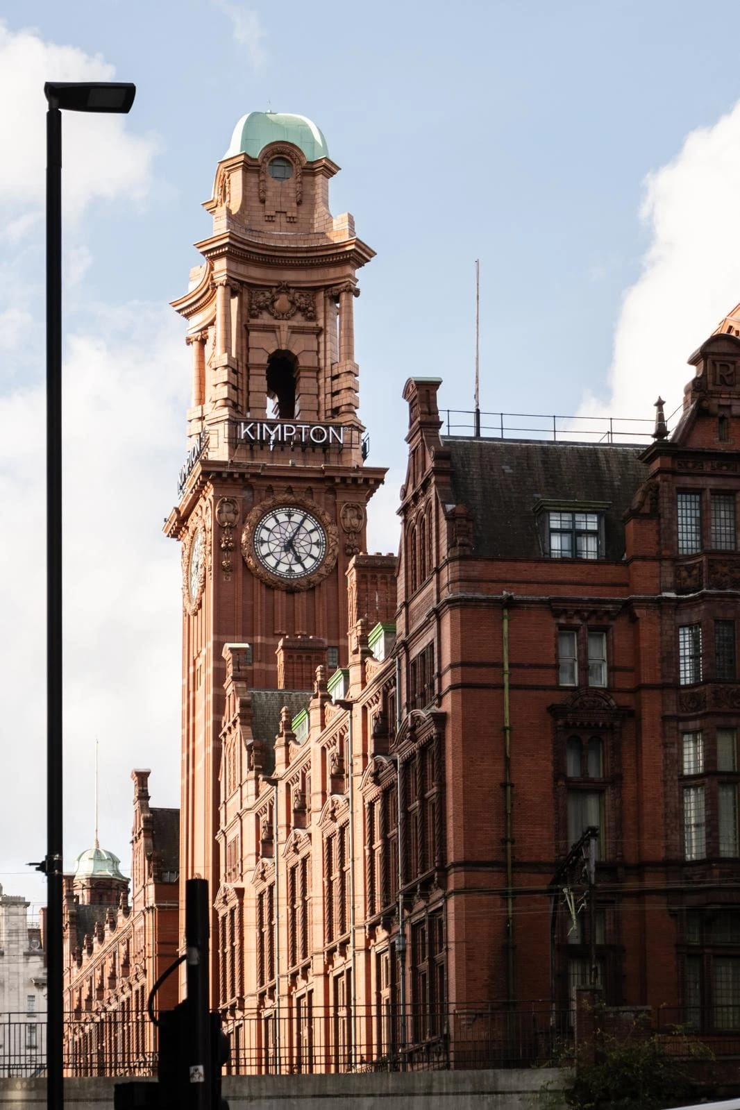 Red-brick clock tower seen from street level