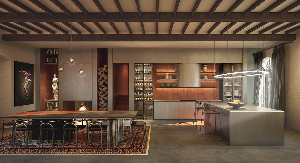 Kitchen and dining room with timber-beamed ceiling, a long dining table on a patterned rug, a fireplace with stacked logs, a glazed wine cabinet and a stone kitchen island with a ring pendant light.