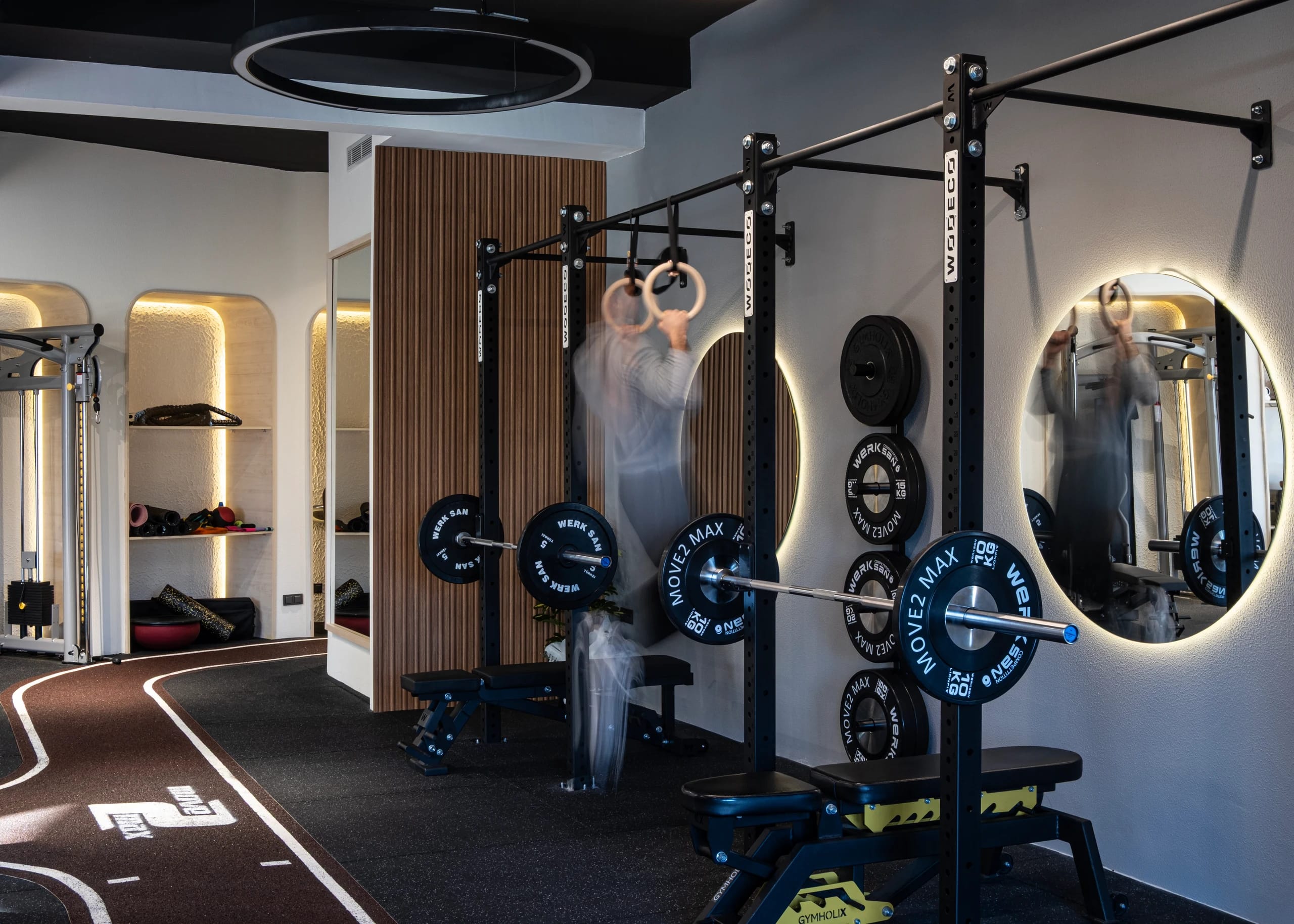 Strength training area with illuminated mirrors.