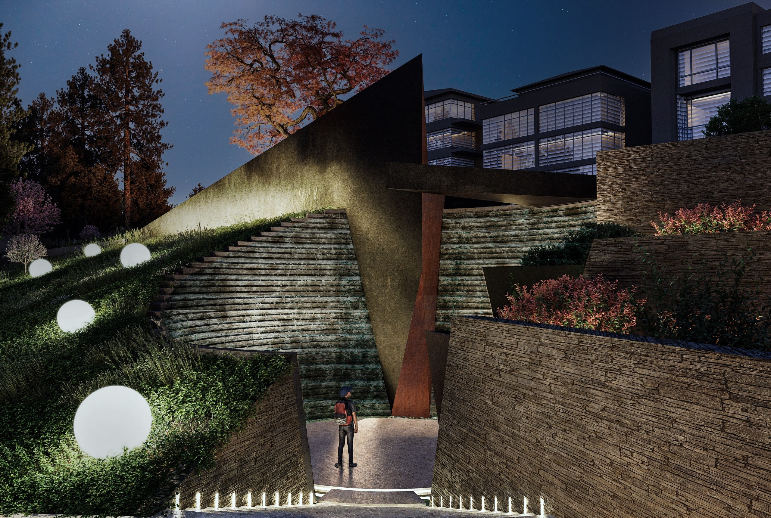 Night view of the memorial in Ankara's Botanic Park, with a figure standing in a lit circular void enclosed by stepped stone walls, a tall angled dark wall with a rust-red steel blade, glowing sphere lights on a grassy slope and office blocks behind